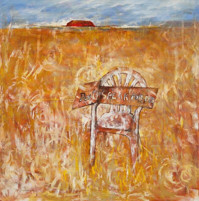 In the centre of the work is a plain white plastic chair, against which propped a piece of cardboard taken apart from a box. It reads: “Please don't speak for me!” In the background is desert. Uluru lies across the horizon. 
